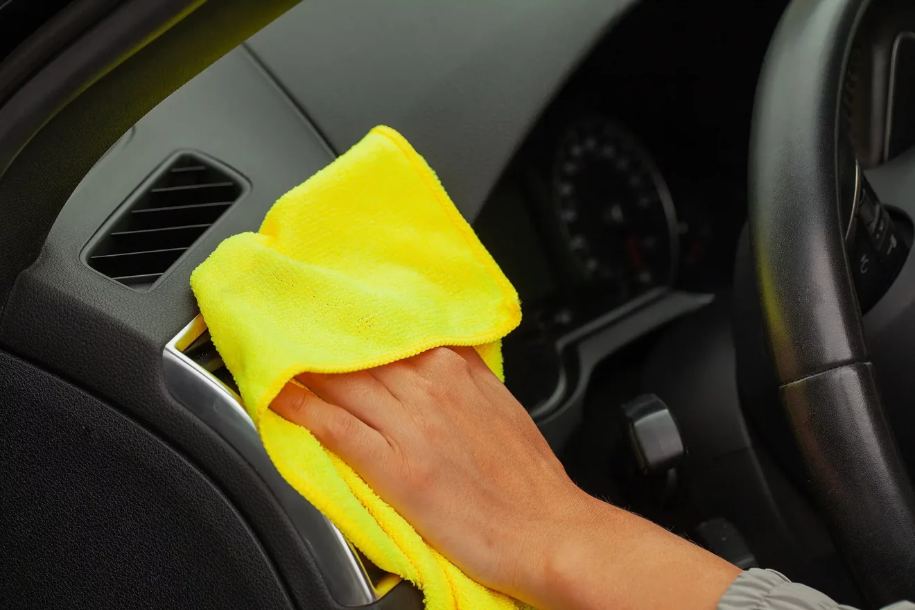 close-up-of-woman-wiping-car-interior-with-yellow-rag