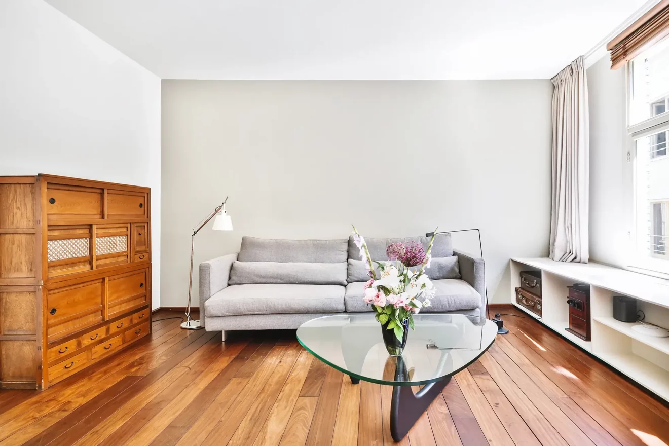 design-interieur-appartement-moderne-spacieux-aire-ouverte-grandes-fenetres-meublees-canape-lit-fonctionnel-table-verre