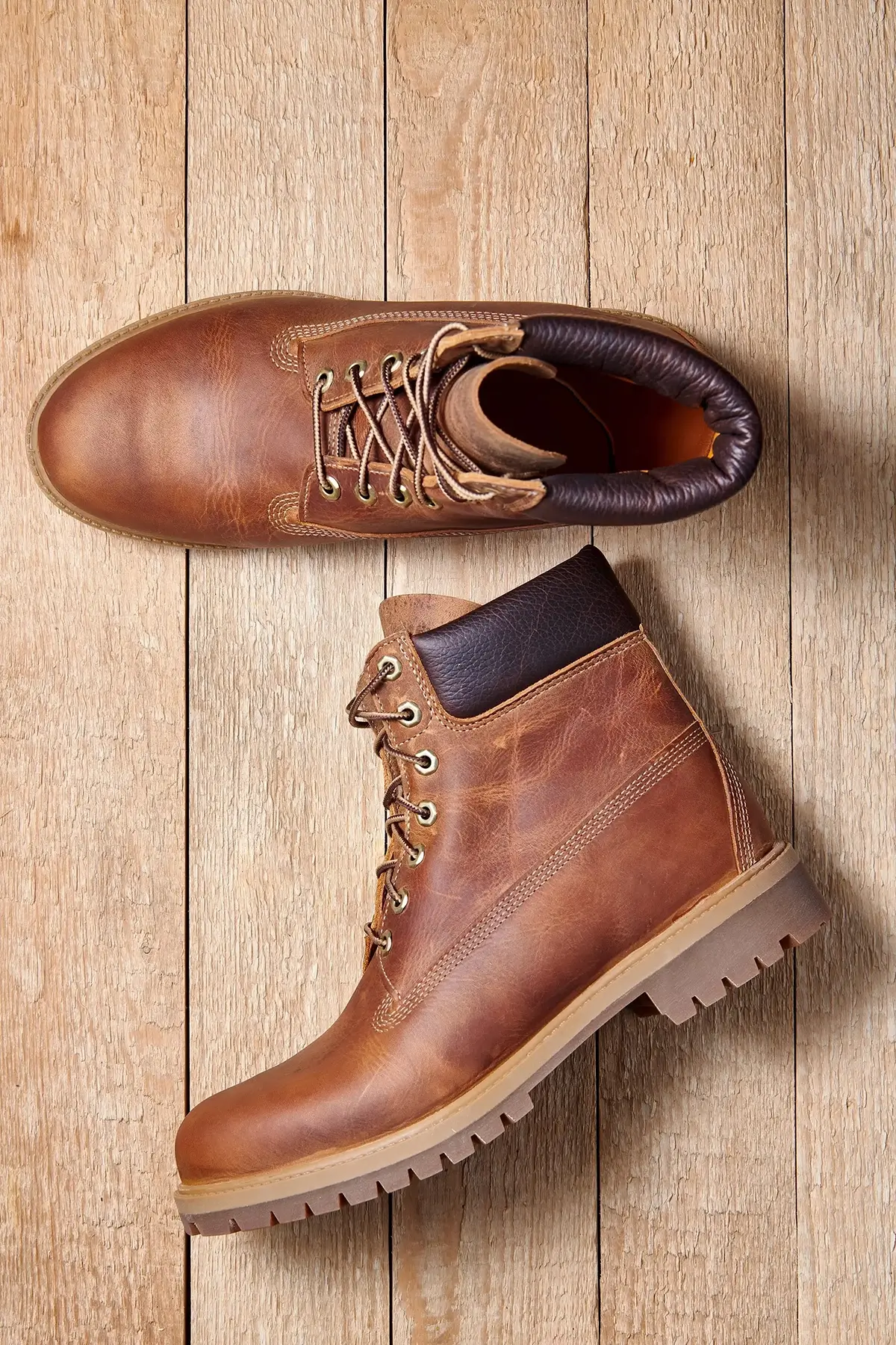 pair-of-men-leather-brown-waterproof-boots-for-winter-or-autumn-hiking-on-wooden-floor