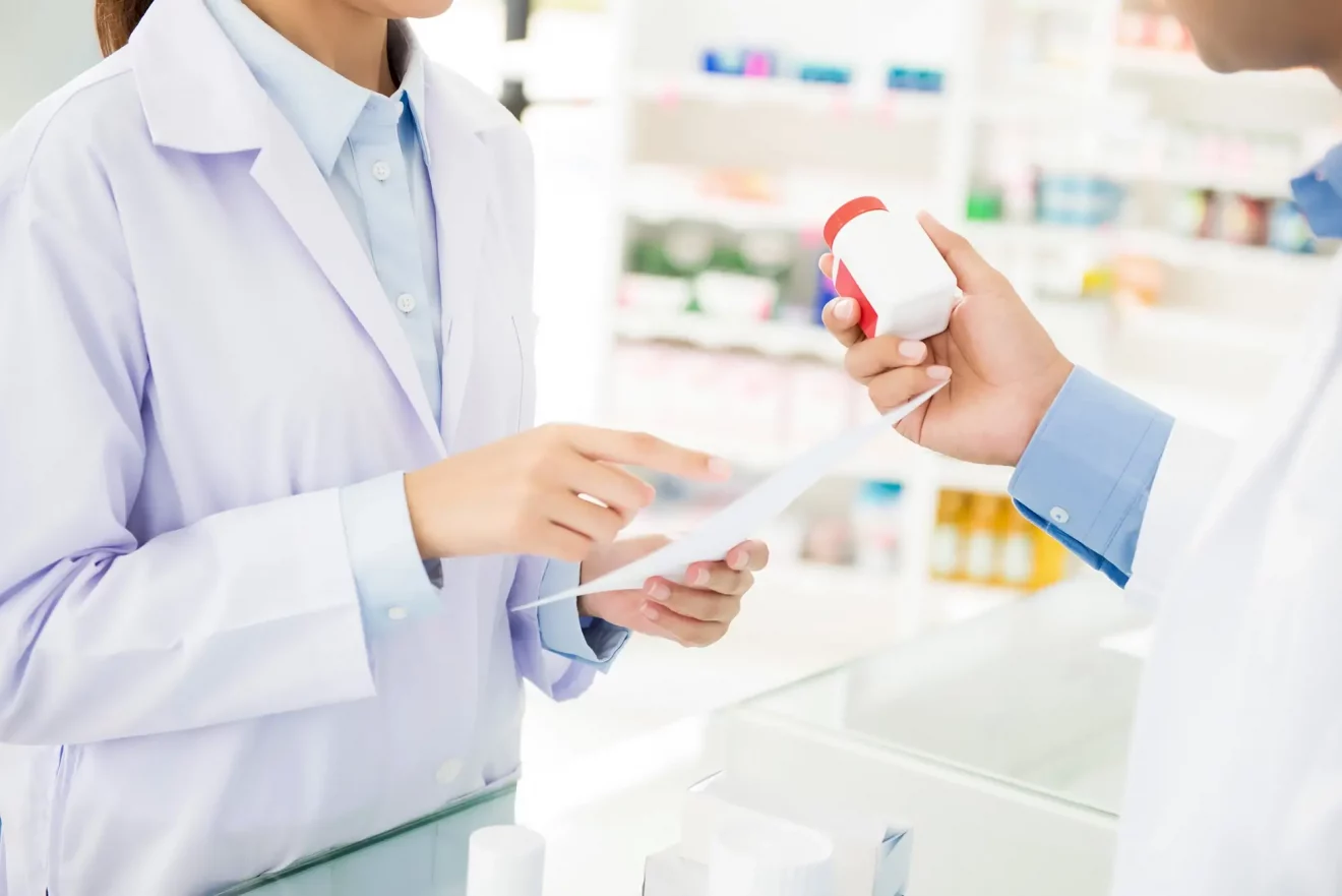 pharmacists-showing-medicine-bottle-and-discussing-prescription-drug-in-pharmacy